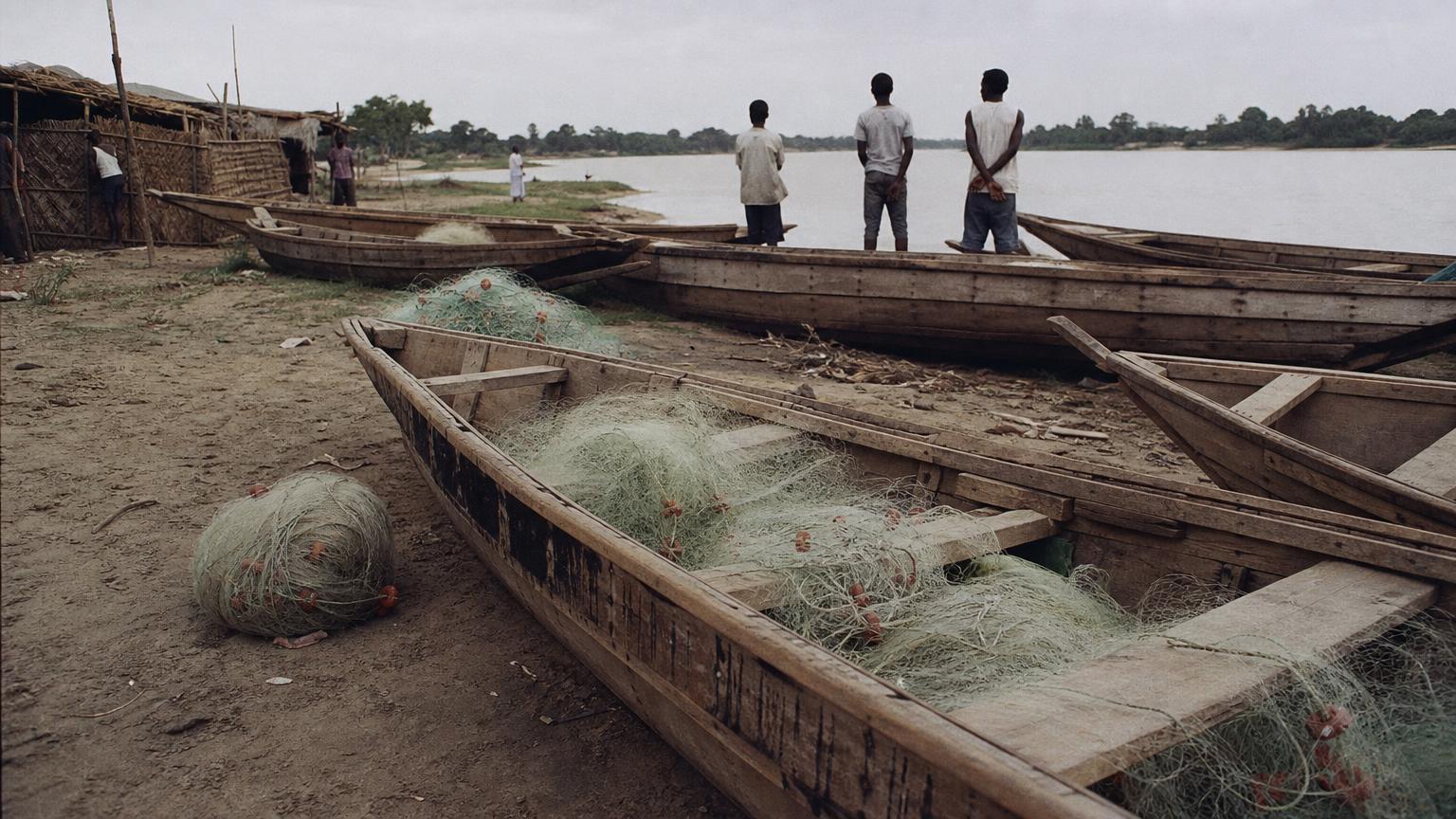 Pirogues de pêche tirées sur la berge sablonneuse du Chari, filets étalés, fin de journée