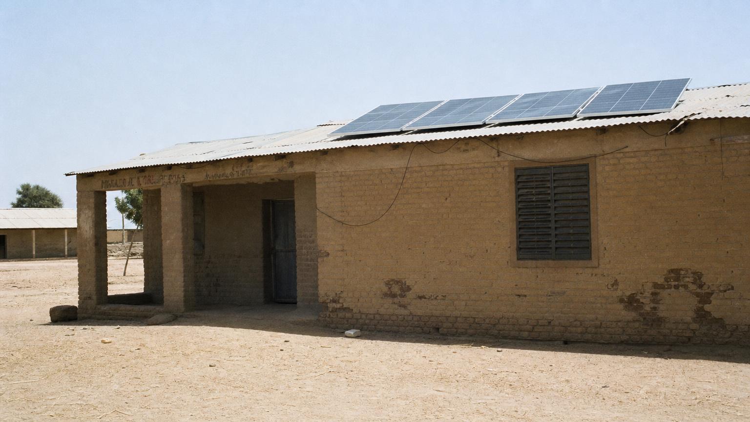 Panneaux solaires installés sur le toit en tôle d'une école en briques de terre